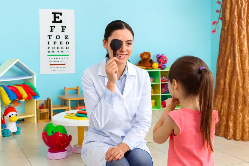 Illustrazione grafica di un simpatico paio di occhiali colorati accanto a una tabella di Snellen con icone di animali e forme per bambini, stile educativo.